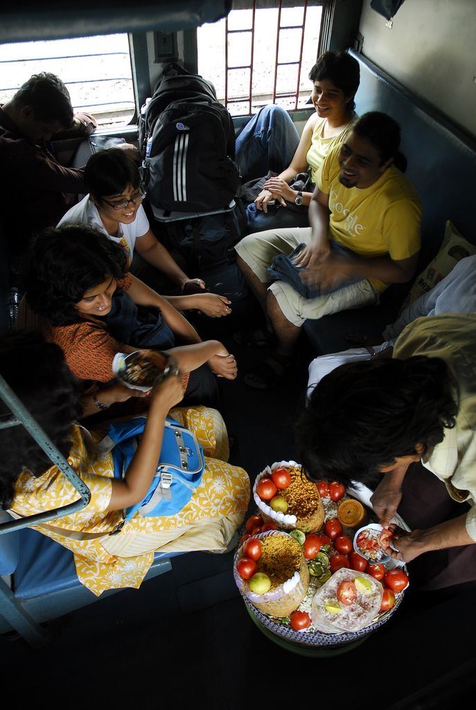 Friends sharing jhalmuri on a train berth